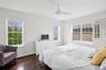 Bedroom featuring dark wood-type flooring, visible vents, baseboards, and a ceiling fan