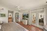 Primary suite offering direct access to the en-suite bathroom, walk-in closet, and pool deck