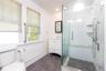 1 st flloor full bathroom. Glass-enclosed shower with white subway tile, a built-in bench, and dual shower heads