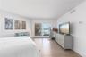 Bedroom with baseboards, visible vents, light wood-type flooring, and access to outside