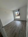 Unfurnished room featuring dark wood-type flooring and baseboards