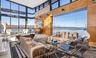 Living room featuring wood walls, a water view, and a high ceiling