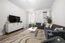 Living room with crown molding, wood finished floors, and radiator