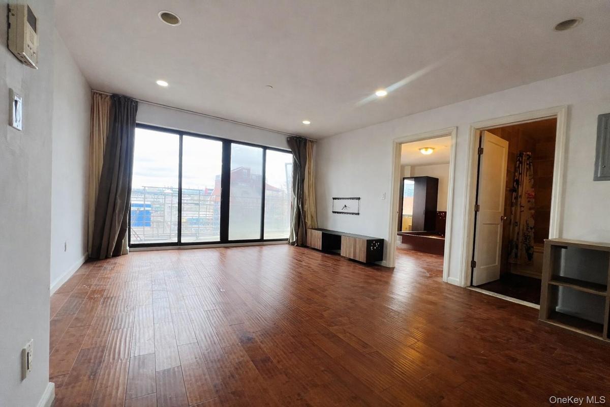 Unfurnished living room featuring dark wood-type flooring
