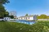 Fenced backyard featuring an outdoor shed, patio, deck off the back sliding glass doors, and an outdoor kitchen area.