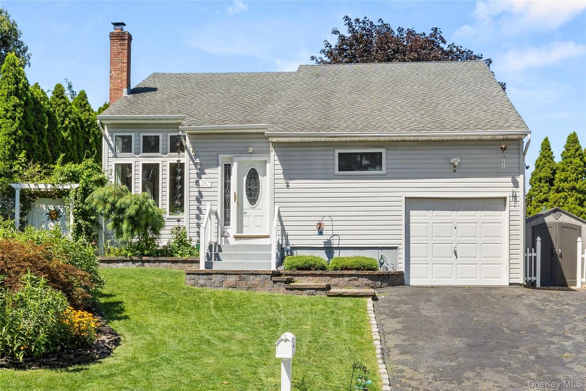 Exterior featuring light gray siding, a single-car garage