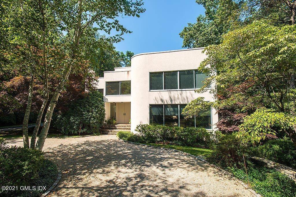 Tree lined drive off of private lane close to town leads to stunning contemporary home surrounded by woods on 3 sides and 300' of Horseneck Brook to the East.
