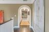 Hall featuring crown molding, dark wood-type flooring, and arched walkways