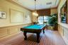 Recreation room in the clubhouse, featuring a decorative wall, crown molding, wainscoting, billiards table, and recessed lighting