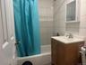 Bathroom with vanity and shower / tub combo with curtain