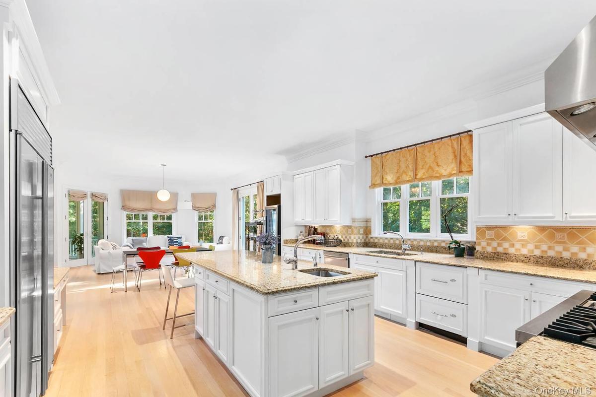 Kitchen with white cabinets, light wood-style floors, and light stone counters
