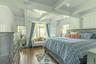 Bedroom with dark wood-type flooring, multiple windows, and beamed ceiling