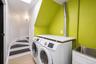 Dedicated laundry area featuring a front-loading washer and dryer, a utility sink with a white base cabinet, a built-in countertop, and a skylight