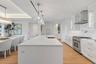 Custom frameless contemporary wood cabinetry with full-extension drawer glides, soft-close drawer and doors, complemented by under-cabinet lighting.
