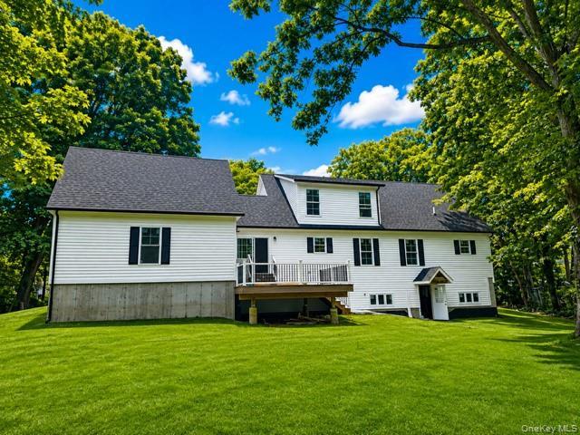 Expansive rear view showcasing the full walkout basement, 16' × 16' Trex deck, private backyard, mature trees, and generous outdoor space.