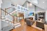 Open-concept living area featuring a vaulted ceiling and hardwood flooring