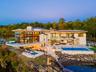 Back of property with a patio area, a swimming pool with hot tub, and a water view