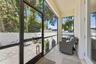 Screened-in porch overlooking a fully fenced in backyard with paver patio for entertaining, professional landscaping, and irrigation system