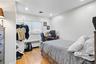 Bedroom with light wood-style floors, radiator heating unit, an office area, and recessed lighting
