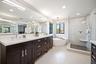 Owner's suite bathroom features a supersized dual sink vanity, freestanding tub and frameless glass shower