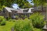 An inviting outdoor space with views across the surrounding gardens, thoughtfully positioned between the home’s east and west wings