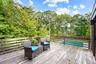 Wooden terrace featuring view of wooded area