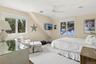 Bedroom with multiple windows, carpet flooring, a ceiling fan, and vaulted ceiling