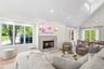 Living area with healthy amount of natural light, high vaulted ceiling, a high end fireplace, wood finished floors, and recessed lighting