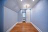 Hardwood flooring and recessed lighting illuminate this interior space, featuring a window with a radiator below