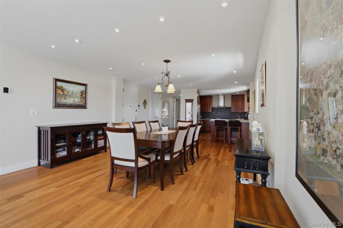 Open-concept dining area with wood-finish flooring, recessed lighting, and a chandelier