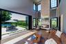 Furnished living room with a fireplace, wood finished floors, and a high ceiling