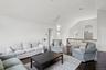Living room featuring dark wood-type flooring, visible vents, and vaulted ceiling