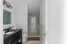 Bathroom featuring vanity, toilet, and a shower with door