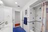 Full bath featuring shower / tub combo with curtain, vanity, dark tile patterned flooring, and recessed lighting