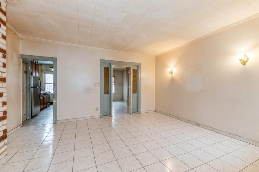 Spare room featuring ornamental molding, baseboards, and light tile patterned floors