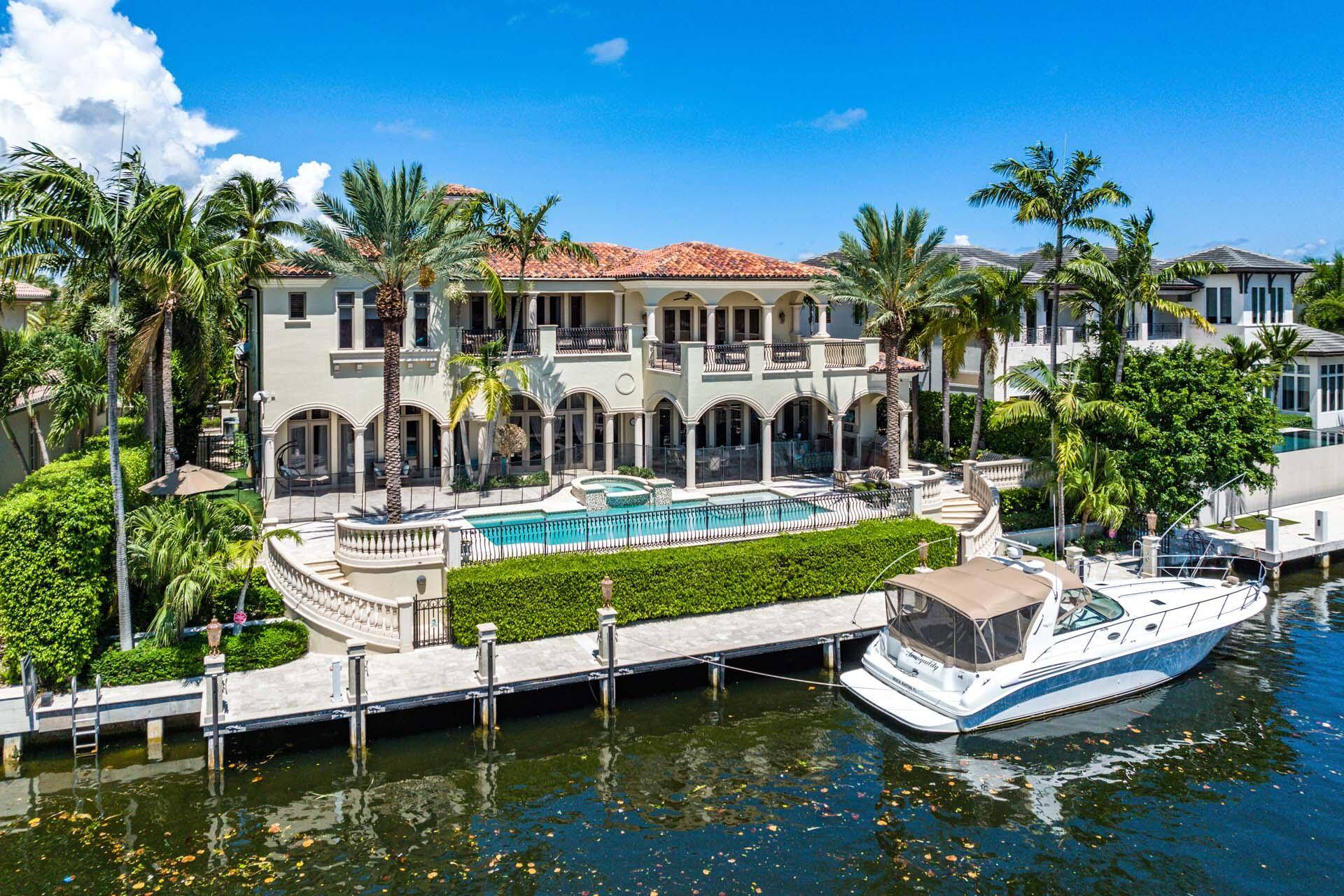 Casa Rosa is a grand waterfront estate located on 112' of the most expansive waterway in Royal Palm Yacht Country Club.