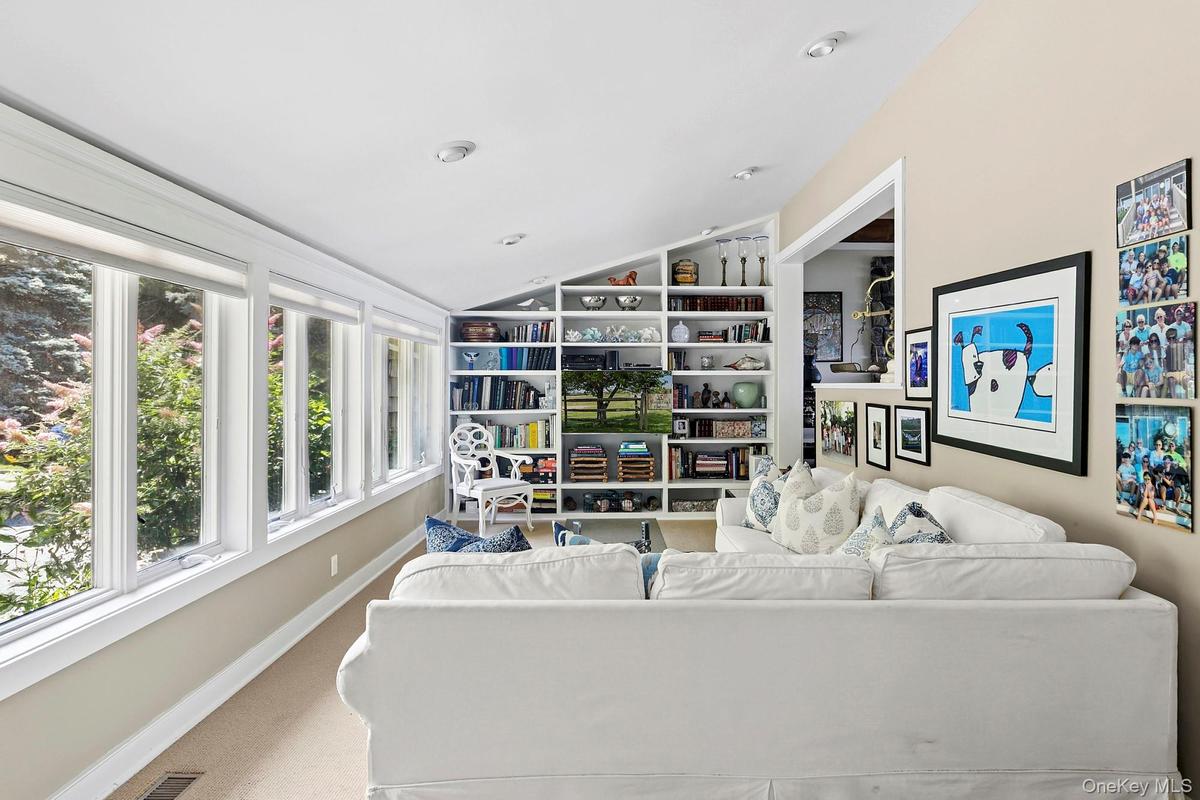 Carpeted living room with vaulted ceiling and baseboards