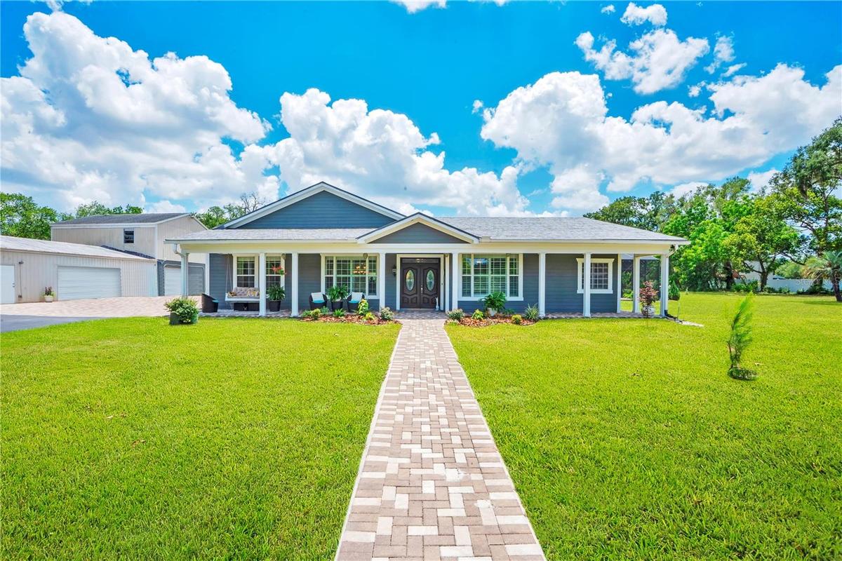 Front View: Metal Tile Shingles, Front Porch with Swing, Paver Walkway to front door and detached garage