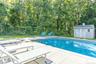 Swimming pool featuring a patio and a shed