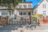 This beautiful multi-level home stands out with its eye-catching white iron gates, classic brick pillars, and a welcoming front porch. Shaded by matur