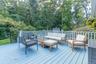 Wooden terrace with an outdoor hangout area and view of wooded area