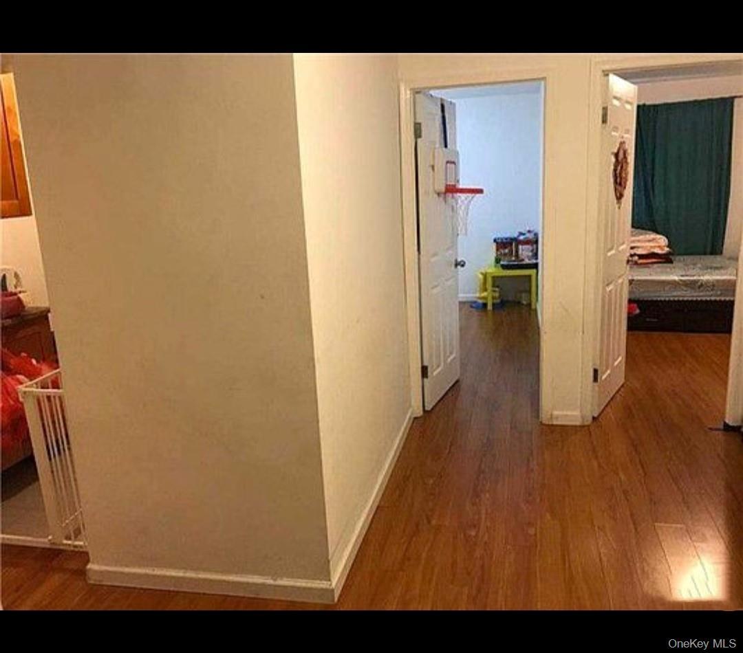 Hallway featuring dark wood finished floors and baseboards