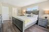 Bedroom featuring dark wood-style floors and ensuite bath