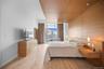 Bedroom with light wood-style floors and a wall of windows