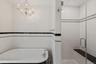 Bathroom featuring a freestanding bath, a stall shower, and tile walls
