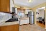 Kitchen featuring a gas range, stainless steel refrigerator, and tiled backsplash