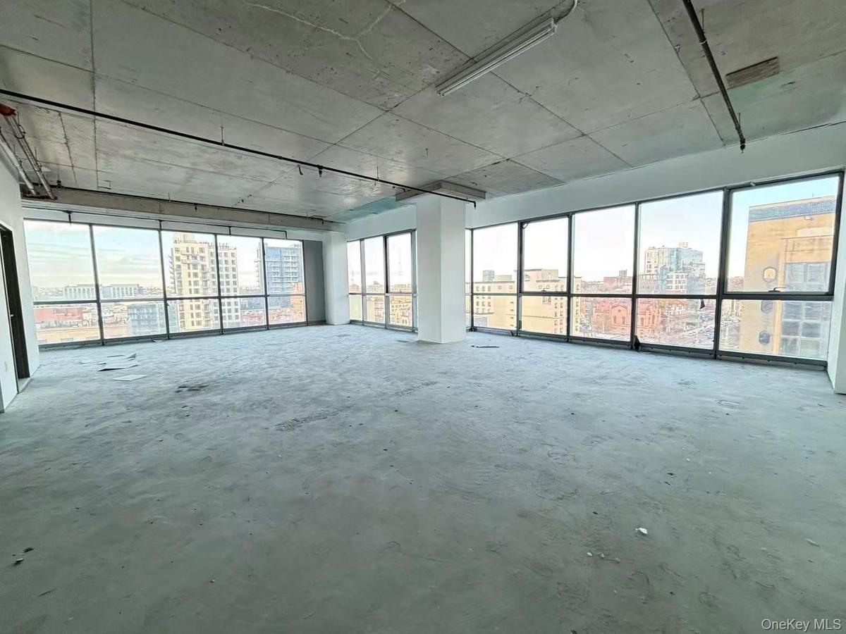 Empty room with a view of city and unfinished concrete floors