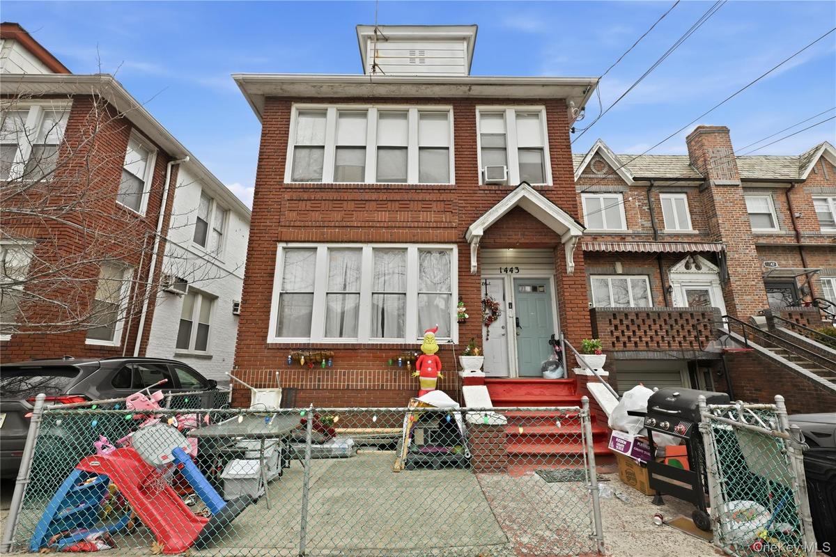 View of front of house featuring a fenced front yard, a gate, and brick siding