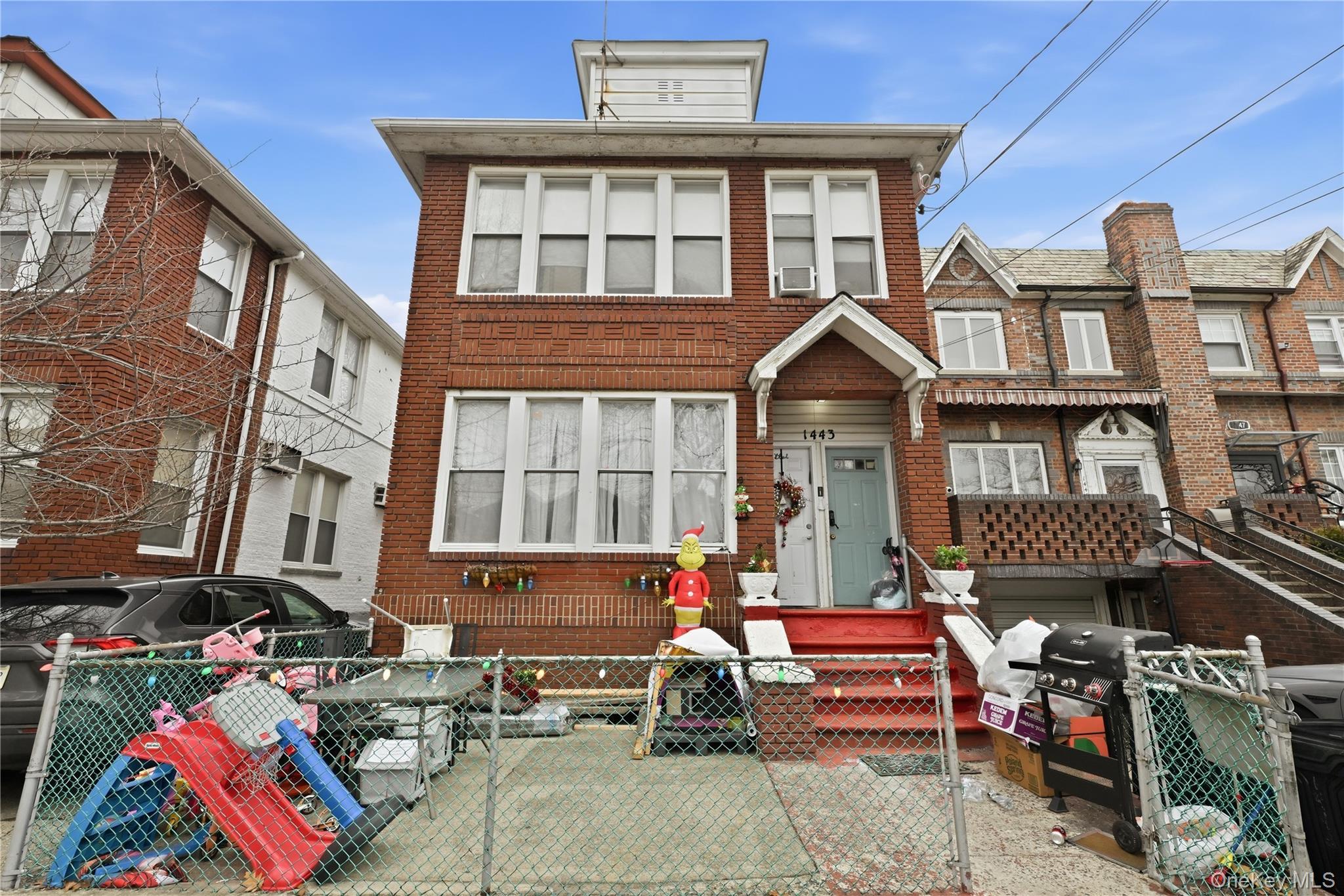 View of front of house featuring a fenced front yard, a gate, and brick siding