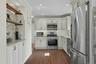 Kitchen featuring built in coffee/tea bar with open shelving above and storage below. Recess lighting.